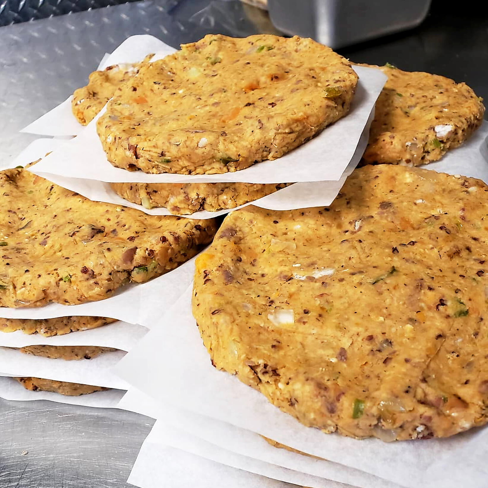 A stack of Grown and Grazed veggie burgers, made fresh in-house and ready for the grill